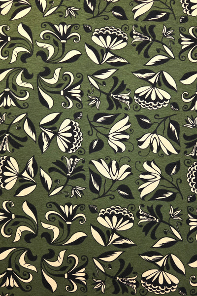 A close-up of a repeating floral pattern on fabric featuring cream and black botanical motifs on an olive green background.