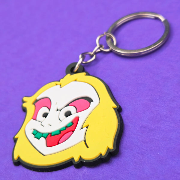 soft touch rubber keychain in the shape of cartoon series version of Beetlejuice in red, pink, green, white, and yellow. On a split ring 