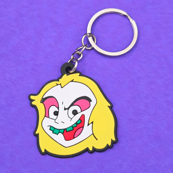 soft touch rubber keychain in the shape of cartoon series version of Beetlejuice in red, pink, green, white, and yellow. On a split ring 