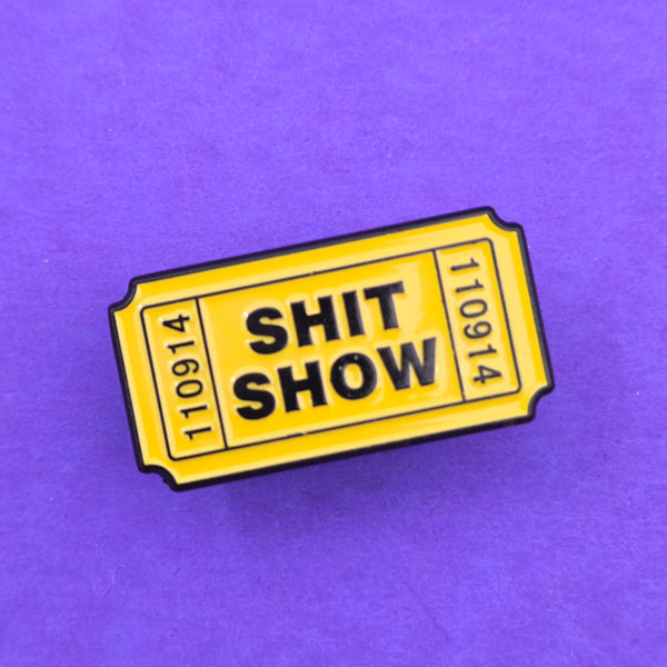 1.25" bright yellow glow-in-the-dark "Shit Show" ticket soft enameled black metal pin