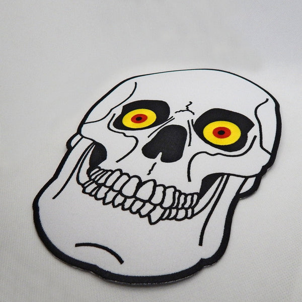 Large backpatch of a white skull with thick black outline and details and red and yellow eyes. Shown in close up