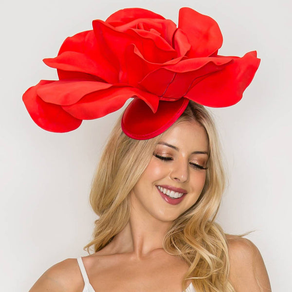 model wearing oversized red satin rose fascinator. Shown from front