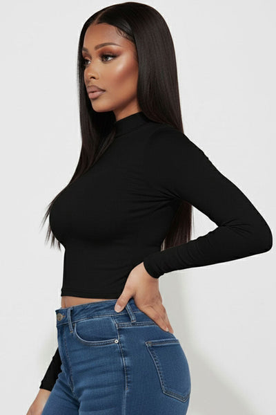 model wearing black long sleeve mock neck crop top. Shown from side