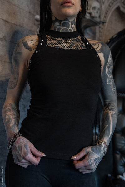 a model wearing a black knit sleeveless top with crew neckline, silver eyelet detail at each armhole, and black fishnet detail below the neck opening. Shown from front