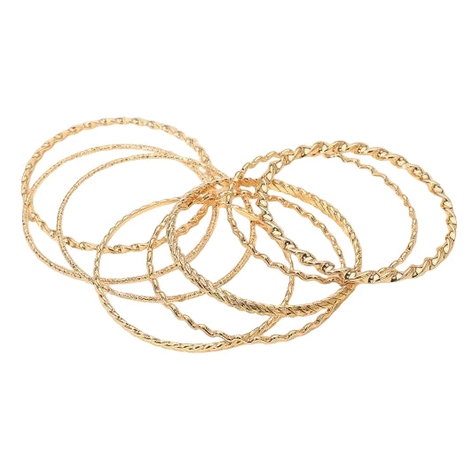 set of eight various textured wavy and twisted gold metal bangles shown scattered