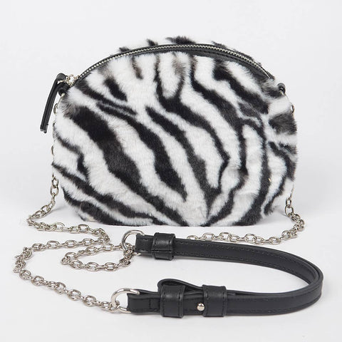 Zebra print black and white faux fur handbag with a chain strap and faux black leather shoulder piece on a white background