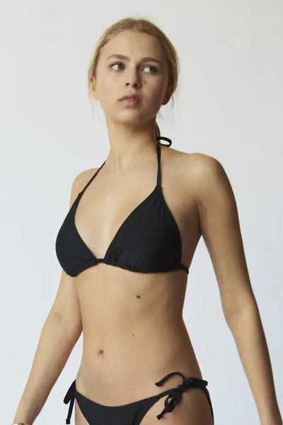 Woman wearing a black bikini against a plain background