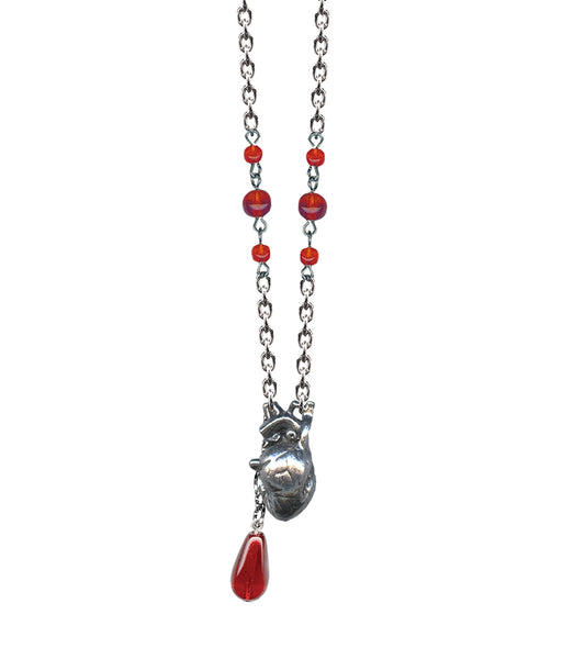 Necklace with a pewter anatomical heart pendant and red glass beads, including drop of blood shaped bead attached to heart charm shown in close up
