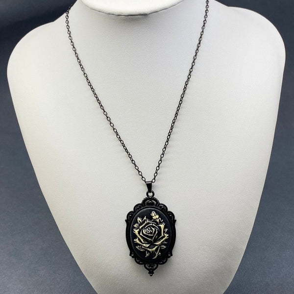 Black and white rose cameo pendant on black link chain necklace on a mannequin bust