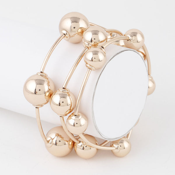 Set of three differently sized plastic metallic gold stretch bracelets with round beads in between long segments