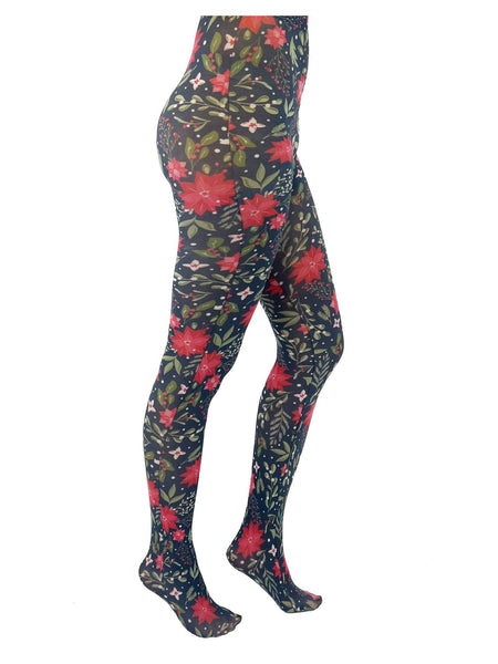 A model wearing opaque tights with a poinsettia, holly, and snowberry pattern on a forest green background. Seen from side