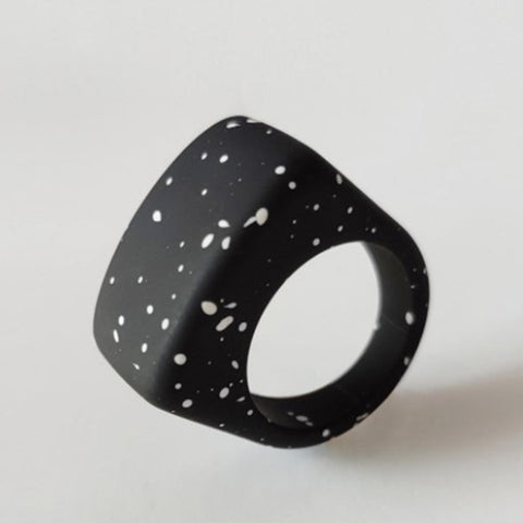 Rectangular black acrylic ring with irregular white spots