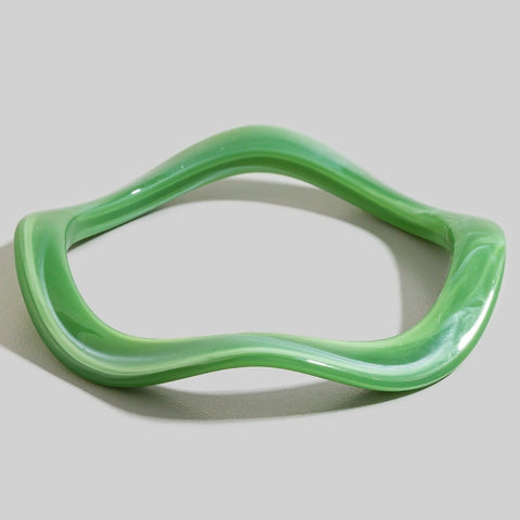 wavy shaped resin bangle in shade of bright jade green with white marbling