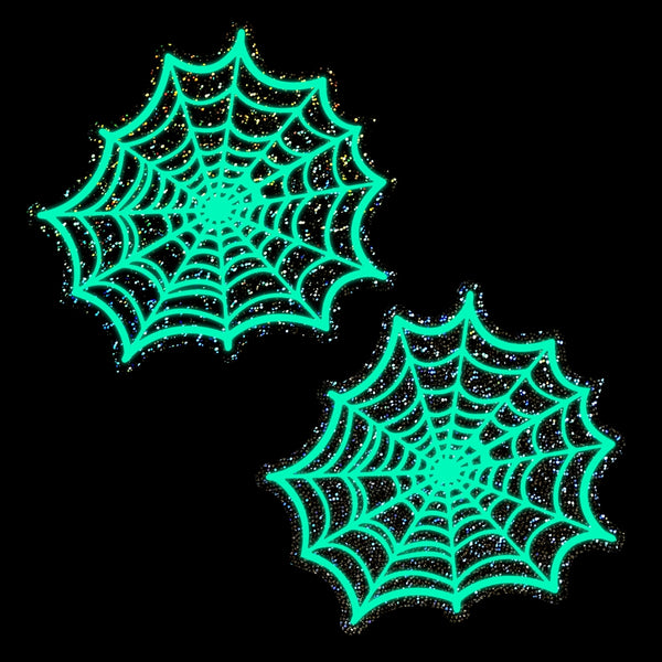 textured black glittery background pasties with white spiderweb design shown in the dark glowing