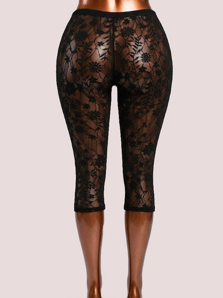 Black floral patterned lace high-waist capri length leggings displayed on a mannequin leg form against a light gray studio background. Shown from back