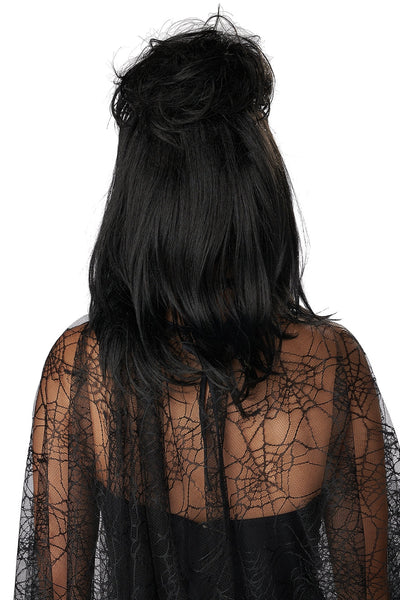 model dressed as Lydia Deetz from Beetlejuice wearing black shoulder length layered wig with spiky bangs and voluminous birds nest updo wearing black lace dress. Shown from back