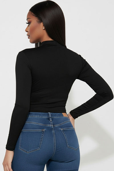 model wearing black long sleeve mock neck crop top. Shown from back