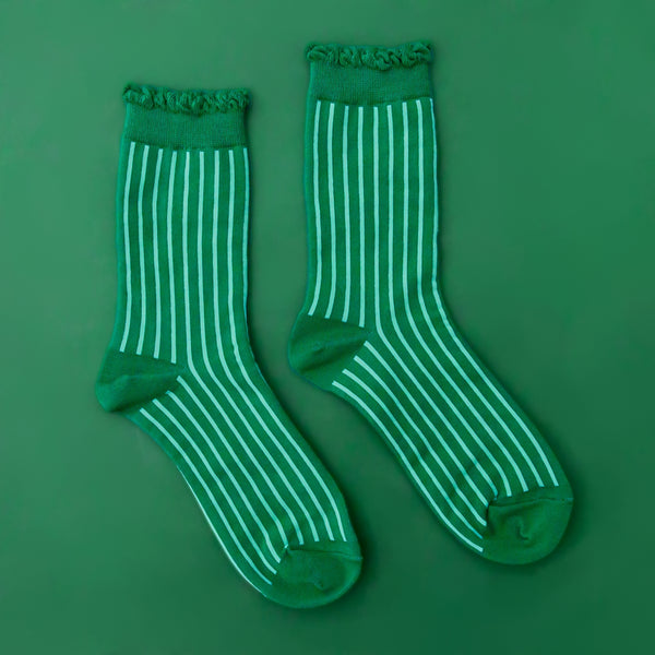 kelly green cotton socks with mint green stripes and ruffled green cuffs on a green background