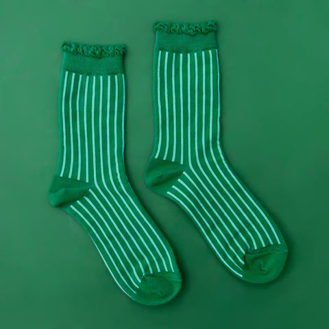 kelly green cotton socks with mint green stripes and ruffled green cuffs on a green background