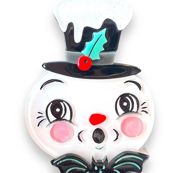 Spooky Frosty Brooch by Johanna Parker x Lipstick & Chrome, surprised face snowman wearing top hat covered with white glittery snow and holly detail with small bat at his collar. Shown on a white background