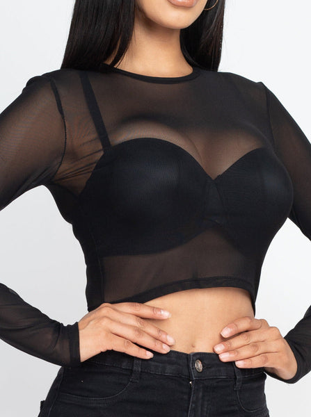 A long sleeved cropped black mesh top with round neck. Worn on model 