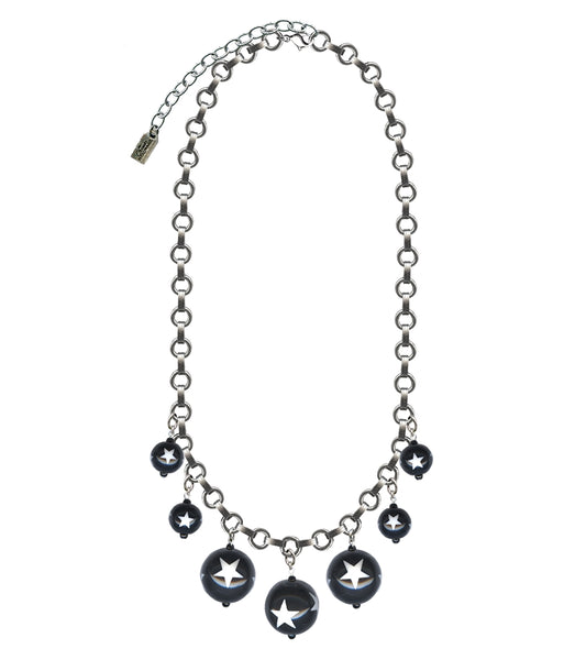 link necklace with 7 varying sizes of round black beads decorated with white stars on a white background