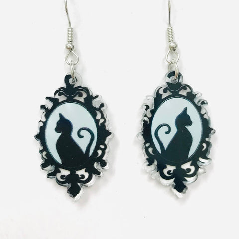 Pair of laser cut acrylic dangle earrings with printed cameo with black cat silhouette design on a white background