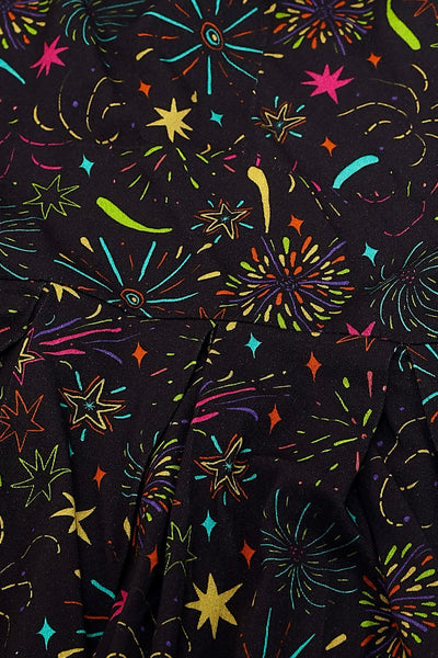 Up close pattern detail shot of soy silk in a black background pattern of exploding fireworks in bright red, pink, green, blue, orange, and purple