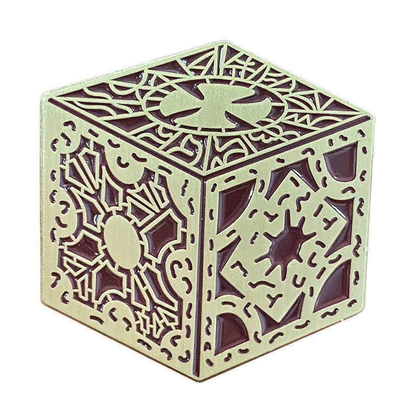 Brown enameled gold metal pin depicting the square puzzle box from Hellraiser