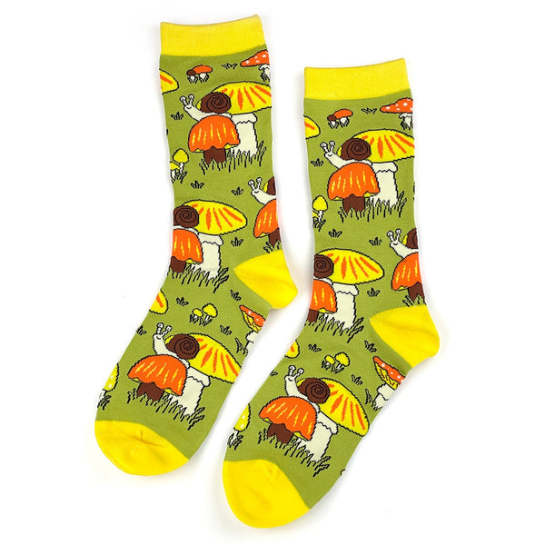 Pair of socks with orange and yellow mushrooms with snails design on a green background. Shown flat