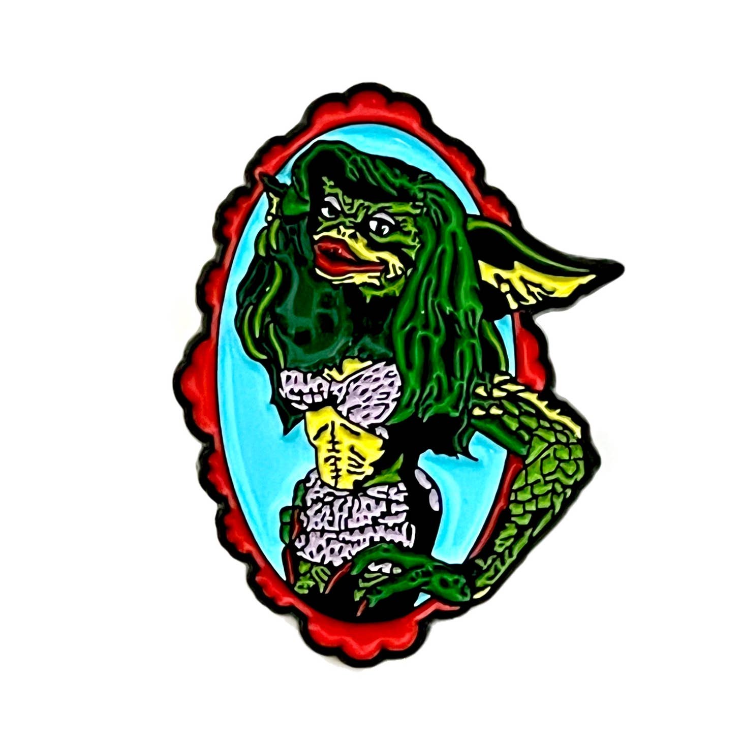 Colorful enamel pin of Greta from the movie Gremlins posed with one arm up in a red and blue oval frame 