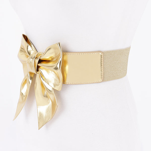 Metallic gold faux leather waist belt with large asymmetrical bow shown from side on dress form