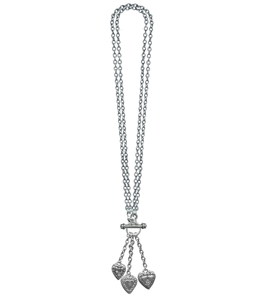 silver metal link chain toggle necklace with trio of heart charms hanging from three smaller chains at front of necklace. Chain shown doubled for shorter necklace