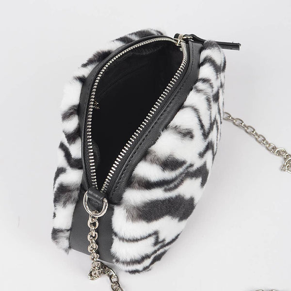 Zebra print black and white faux fur handbag with a chain strap and faux black leather shoulder piece on a white background. Shown unzipped from top