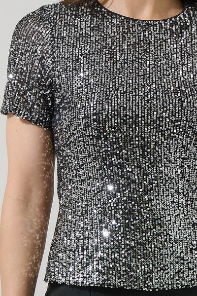 Close-up of a sequined black and silver top on a plain background
