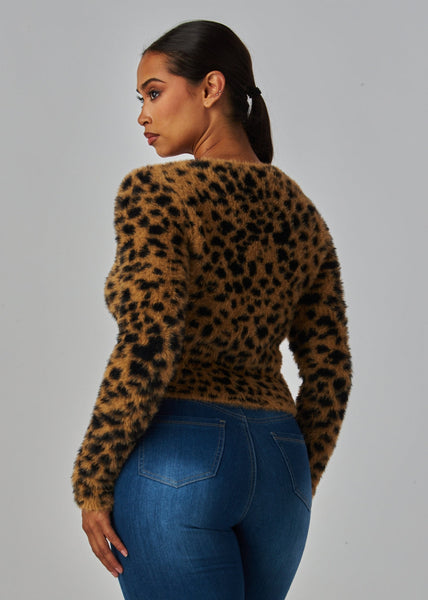 Woman wearing a leopard print sweater in a faux mohair material with long sleeves, slight v-neckline, and matte black plastic buttons. Shown from back