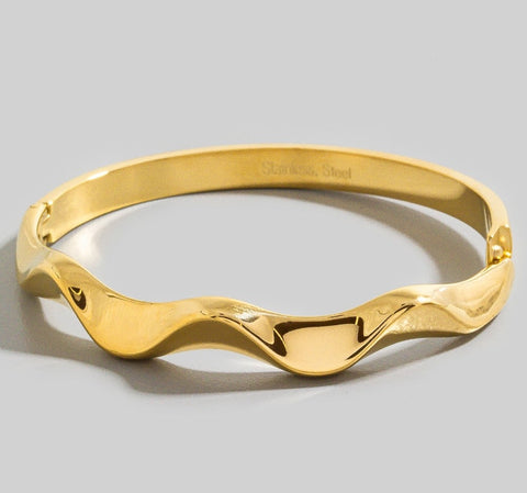 Gold finish stainless steel hinge closure thin bangle with an asymmetrical wavy design