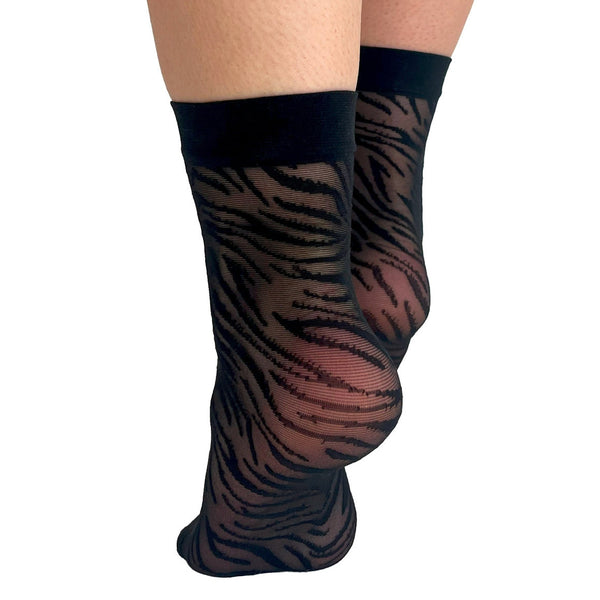 Black mesh ankle socks with a solid black cuff and a tiger print pattern. Shown on a model shown from the back