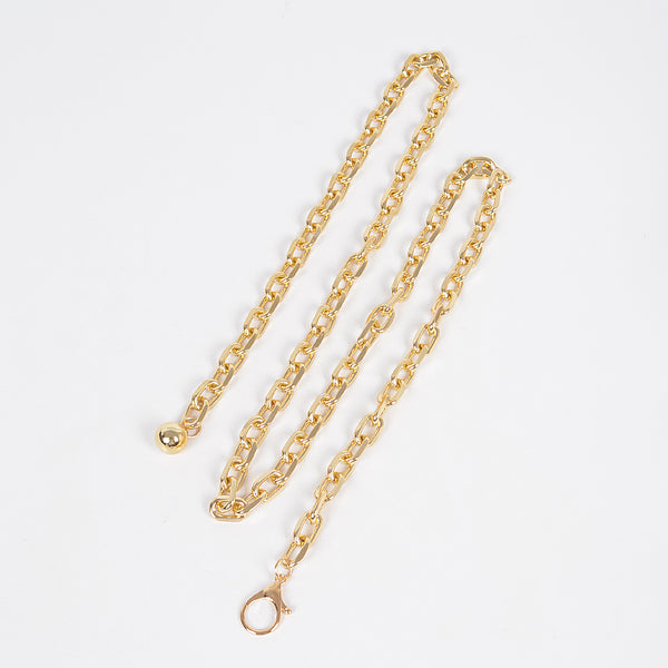 Gold metal link style chain belt with silver round charm at the end shown flat