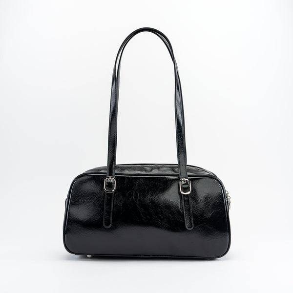 shiny black textured faux leather bowler bag with adjustable shoulder straps, sturdy silver metal zip closure, and studded matching faux leather heart-shaped mirror bag charm. Shown from back