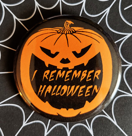 1.25" round button of orange jack-o'-lantern on black background with "I REMEMBER HALLOWEEN" written in orange in its mouth