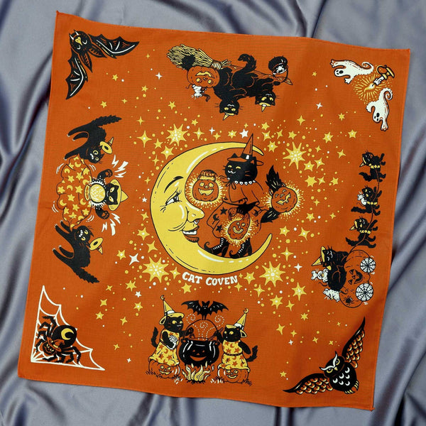 Halloween-themed bandana with cats, moon, and pumpkins on an orange background.