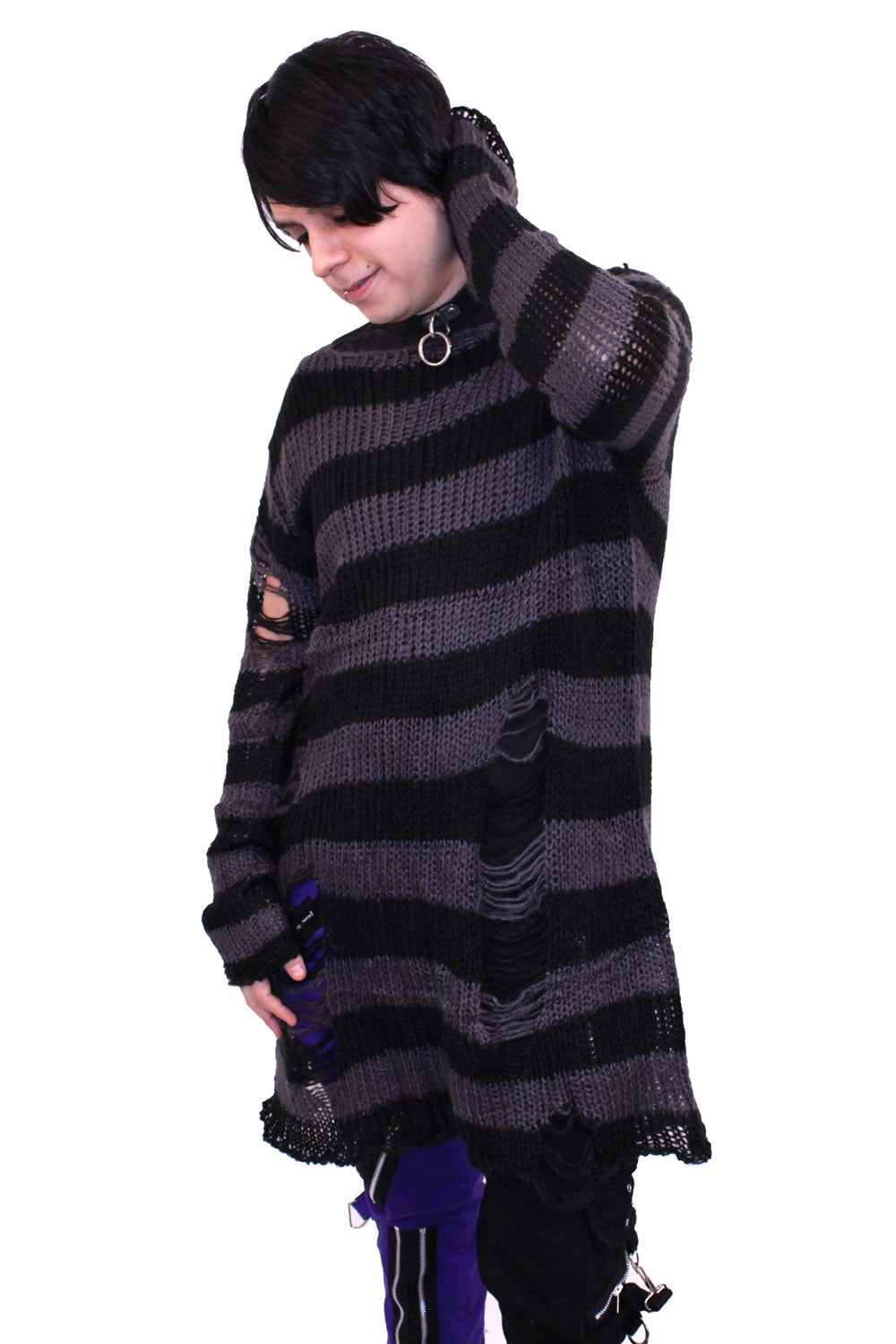 Model wearing an open knit oversized sweater with black and grey stripes and distressed detail at the sleeve and body. Shown from the front
