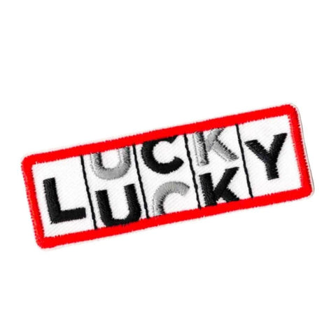 white embroidered rectangular patch and bright red border. The word "LUCKY" is written in black and silver letters in the style of a slot machine rolling