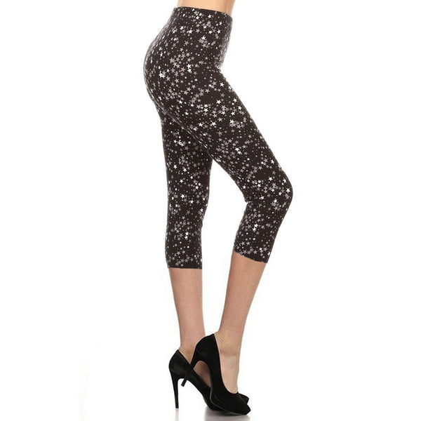 black background white and various shades of grey tiny overlapping stars stretch knit high-waist capri length leggings, shown side view on model