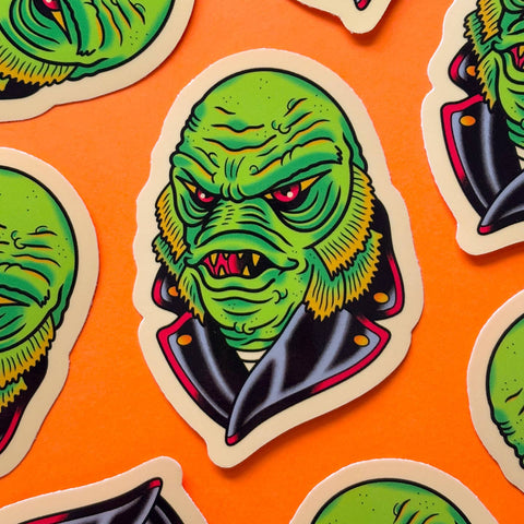 creature from the black lagoon wearing a black leather jacket glossy finish die-cut vinyl sticker on orange background