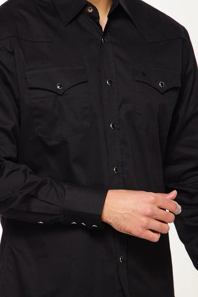 Model wearing a black cotton twill western style button up shirt with black pearl snap closures. Shown from the front in close up 