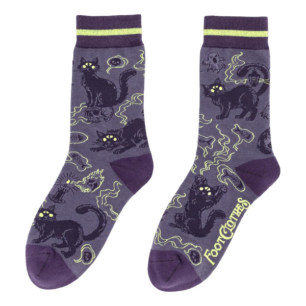 pair of cotton blend unisex crew socks in medium purple with dark purple toes & heels and striped purple and light lime green cuffs. Allover design of dark purple cats with green eyes and large third eyes surrounded by wispy ghosts and spirits. Shown flat from opposite side