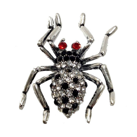 Spider-shaped brooch with red and black gemstones on a white background