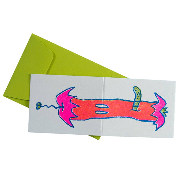 heavyweight card stock note card with a neon pink, coral, green, and blue risograph image of a rotten apple core with worm that wraps around both exterior sides of card. Shown flat with chartreuse envelope